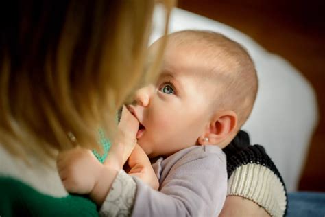Bebé lactando del pecho de su madre, enfatizando el vínculo y la nutrición natural.
