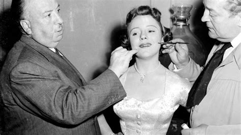 Fotografía de un joven Alfred Hitchcock junto a su padre frente a la tienda familiar