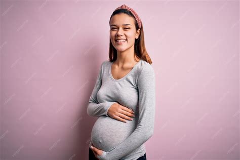 Foto de una mujer embarazada en las últimas semanas, con expresión pensativa pero esperanzadora.
