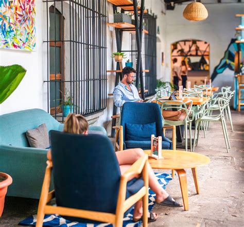 Área común vibrante de un hostal moderno en India con viajeros socializando y planificando