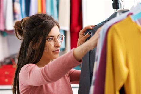 Mujer embarazada eligiendo ropa en un outlet de moda