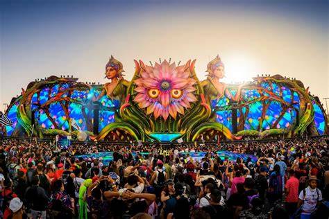 Foto aérea de un festival de música electrónica con miles de asistentes bailando