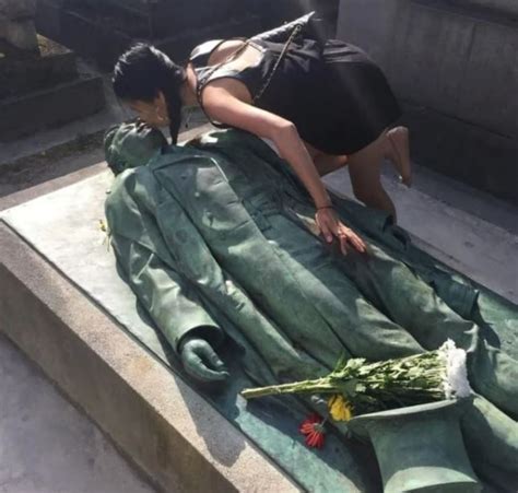 Mujer cumpliendo el rito de besar la estatua de Victor Noir