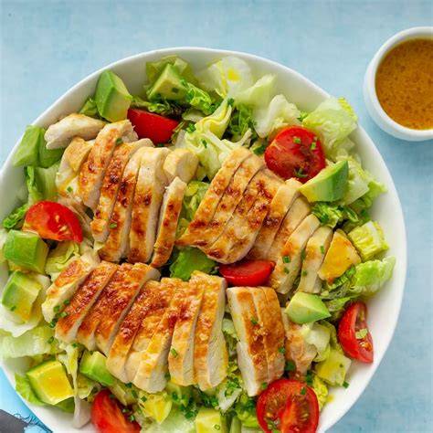 Foto de una ensalada fresca con pollo, aguacate, queso feta y vegetales