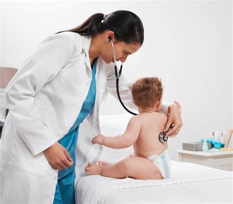Foto de un pediatra examinando a un recién nacido en una consulta.