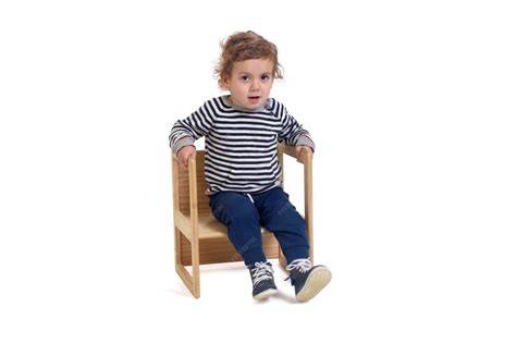 Foto de niño sentado en silla elevadora con respaldo con cinturón correctamente colocado