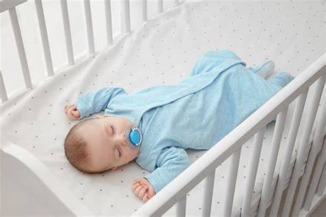 Bebé durmiendo boca arriba en una cuna segura y despejada