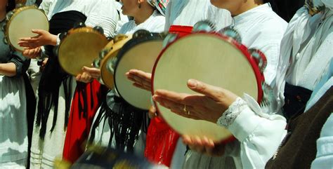 Fotografía de un miembro de una tuna tocando la pandereta con movimientos de baile.