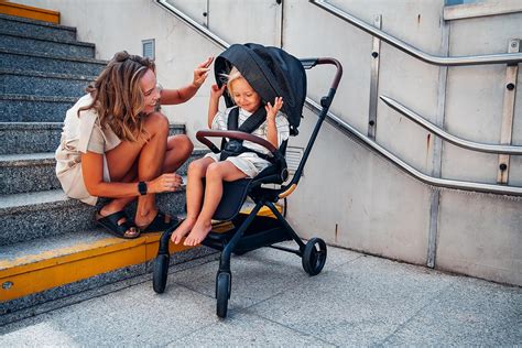 Silla de paseo Elia plegada compactamente, junto a un maletero de coche