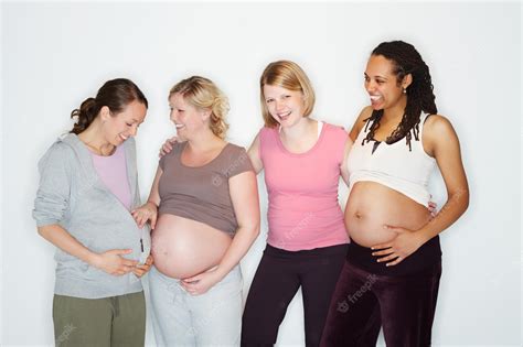Fotografía de un grupo de mujeres embarazadas realizando posturas de yoga suaves en un estudio luminoso.