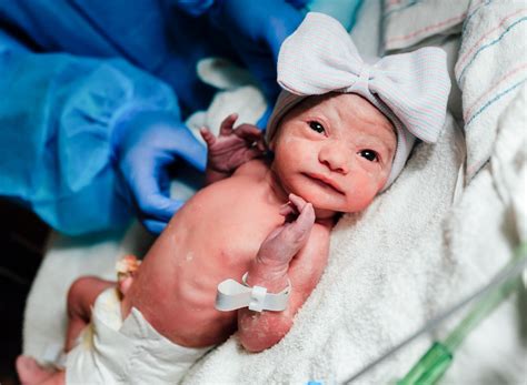 Imagen de un bebé siendo eructado suavemente después de una toma, con un adulto sosteniéndolo en posición vertical.