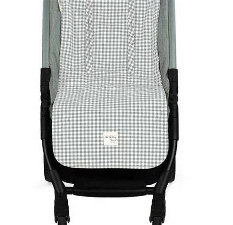 Fotografía detallada de la colchoneta con estampado de cuadros vichy en tono gris instalada en una silla de paseo