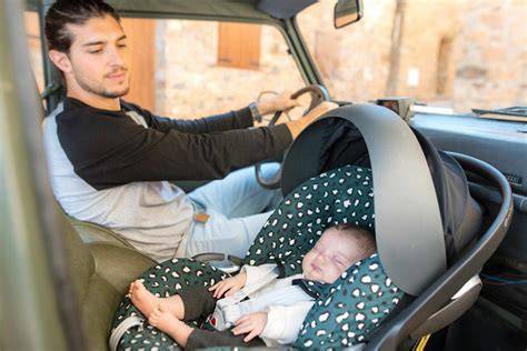 Foto de primer plano de un bebé prematuro durmiendo plácidamente en un cochecito con un reductor de asiento
