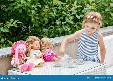 Foto de una niña jugando con una cuna de muñecos y su muñeco