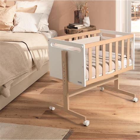 Foto de una minicuna convertible de madera en color blanco y madera en una habitación infantil neutra