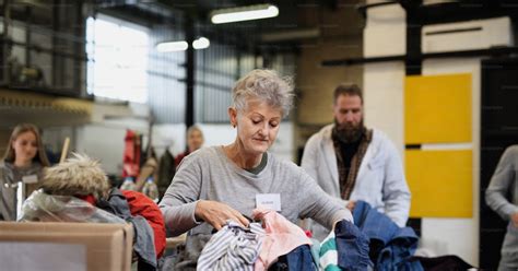 Foto de voluntarios clasificando ropa de bebé donada