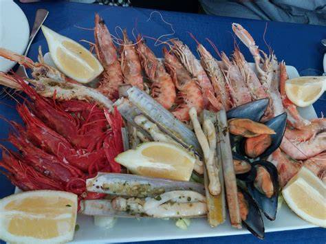 Variedad de mariscos frescos y cocidos en una fuente grande