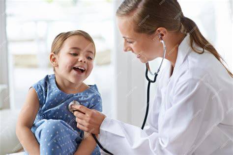 Pediatra sonriendo mientras examina a un niño feliz, mostrando una interacción positiva