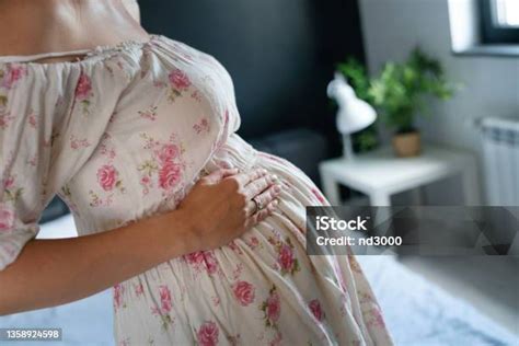 Foto temática de una mujer embarazada tocándose el pecho