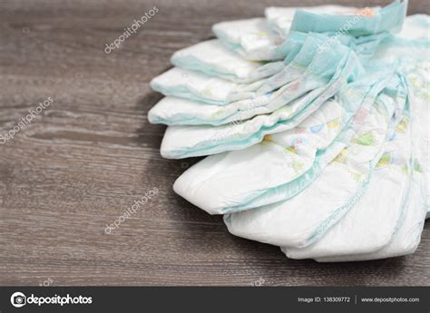 Bebés gemelos con pañales nuevos y una pila de pañales desechables