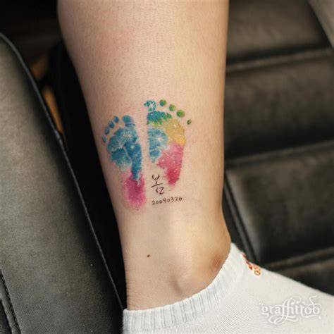 Tatuaje simbólico de huellas de bebé con elementos artísticos