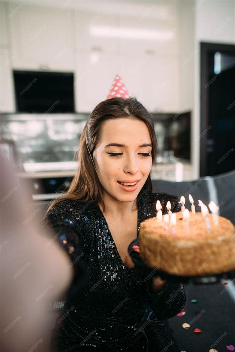 Una joven sonriente celebrando su 25 cumpleaños con un pastel y rodeada de amigos.