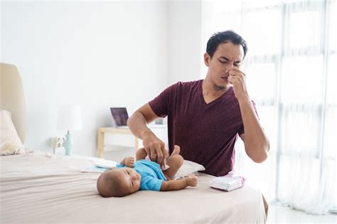 Padre cambiando pañal a su hijo en un baño público