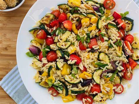 Ensalada de pasta orzo con vegetales frescos y queso feta