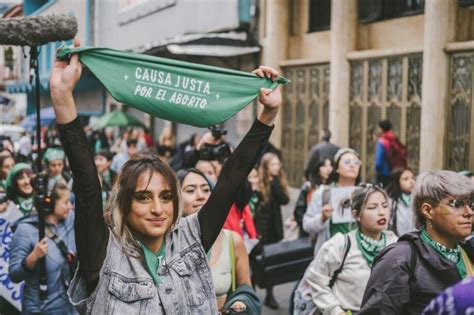 Foto de mujeres manifestándose por el derecho al aborto con pancartas y pañuelos verdes