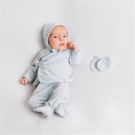 Variedad de prendas de primera puesta Calamaro Baby, como bodies, gorritos y patucos en tonos neutros.