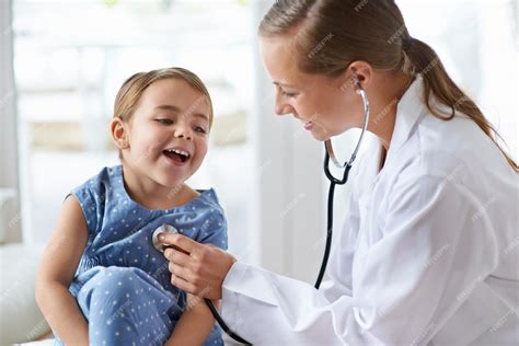 Fotografía de un médico sonriendo amistosamente a un niño en la consulta