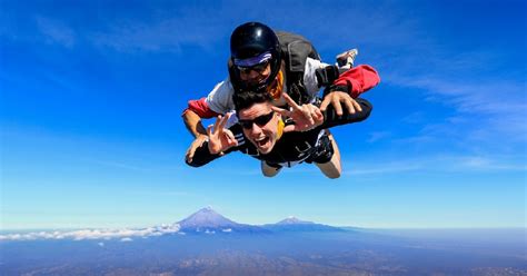 Fotografía de una persona saltando en paracaídas con el paisaje montañoso de Cusco de fondo.