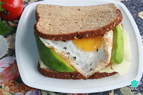 Sándwich abierto con aguacate, huevo, lechuga y brotes.