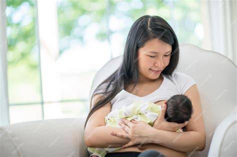 Madre amamantando a su bebé mientras lo lleva en un portabebés ergonómico