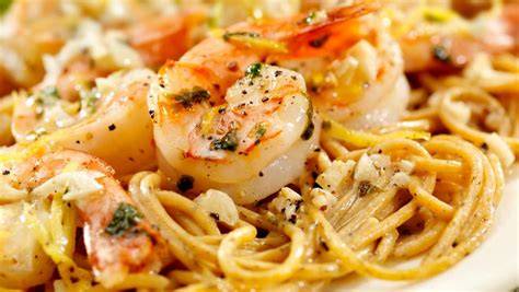 Plato de espaguetis con gambas, espinacas y queso feta listo para servir