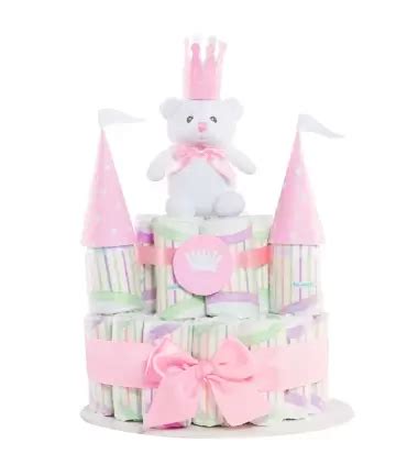 Detalle de un castillo de pañales decorado con cintas rosas y pequeños accesorios para niña.