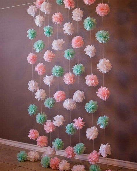 Decoración de fiesta con guirnaldas de papel reciclado y flores naturales.