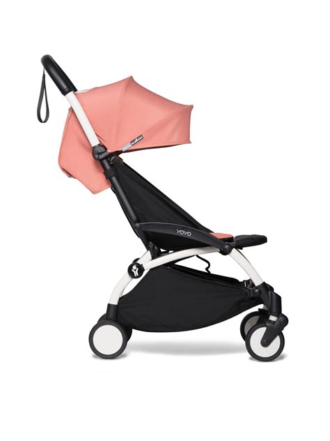 Foto de la silla de paseo Babyzen YOYO² plegada junto a una maleta de cabina