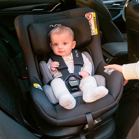 Imagen temática: Bebé sonriendo en una silla de coche con diseño de Mickey Mouse