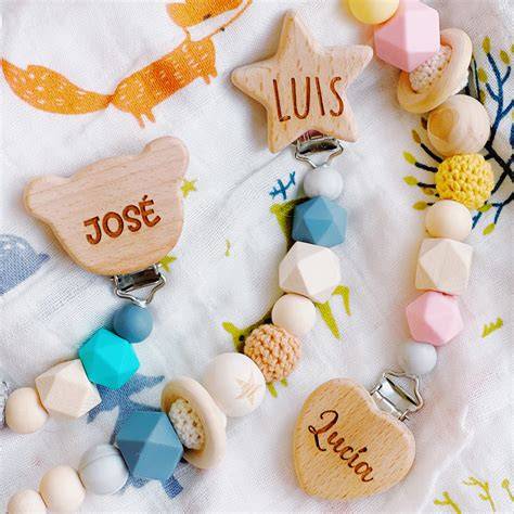 Foto de un chupete personalizado con su chupetero a juego de silicona y madera