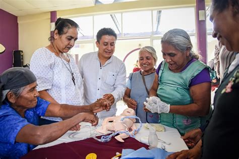 Foto de una partera tradicional con varias generaciones de mujeres