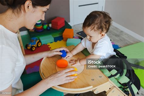 fisioterapeuta jugando con un niño durante una sesión de rehabilitación