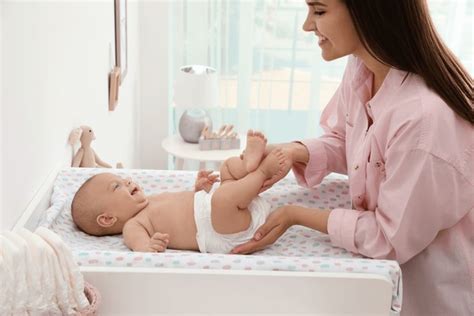 Foto de un bebé siendo cambiado en un cambiador con baldas