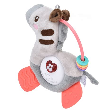 Bebé jugando feliz con un mordedor de peluche con forma de hipopótamo rosa en una cuna