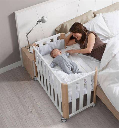Minicuna colecho con un edredón de diseño de estrellas, mostrando a un bebé durmiendo