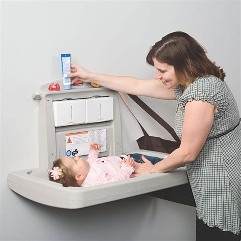 Fotografía de un cambiador de bebé con escaleras integradas y compartimentos de almacenamiento, mostrando su accesibilidad.