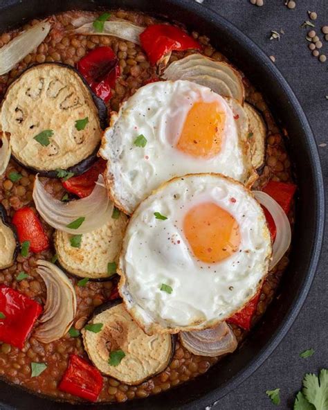 fotografía de un plato de lentejas de bote con verduras asadas y un huevo frito encima