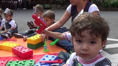 Niños de 2-3 años jugando en un jardín infantil, destacando interacción y materiales lúdicos.