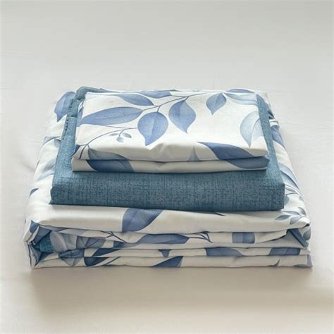 Ilustración de un juego de sábanas de cuna con estampado de Mickey Mouse, mostrando la sábana encimera y la funda de almohada.