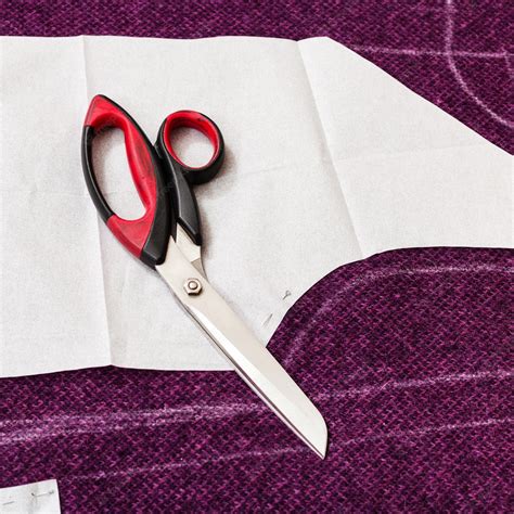 Patrón de papel colocado sobre las telas dobladas para su corte.